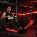 Zawodnik HYROX na stacji treningowej z sankami w hali sportowej