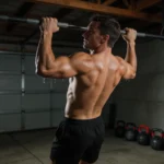 Crossfiter wykonujący trening obwodowy w ciemnej siłowni