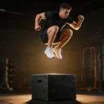 Sportowiec wykonujący eksplozywny box jump w ciemnej siłowni crossfit