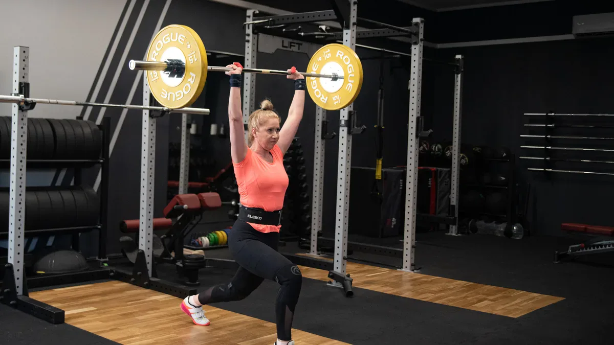 Clean and jerk: odbiór podrzutu w nożycach, sztanga nad głową na prostych rękach, tułów pionowo