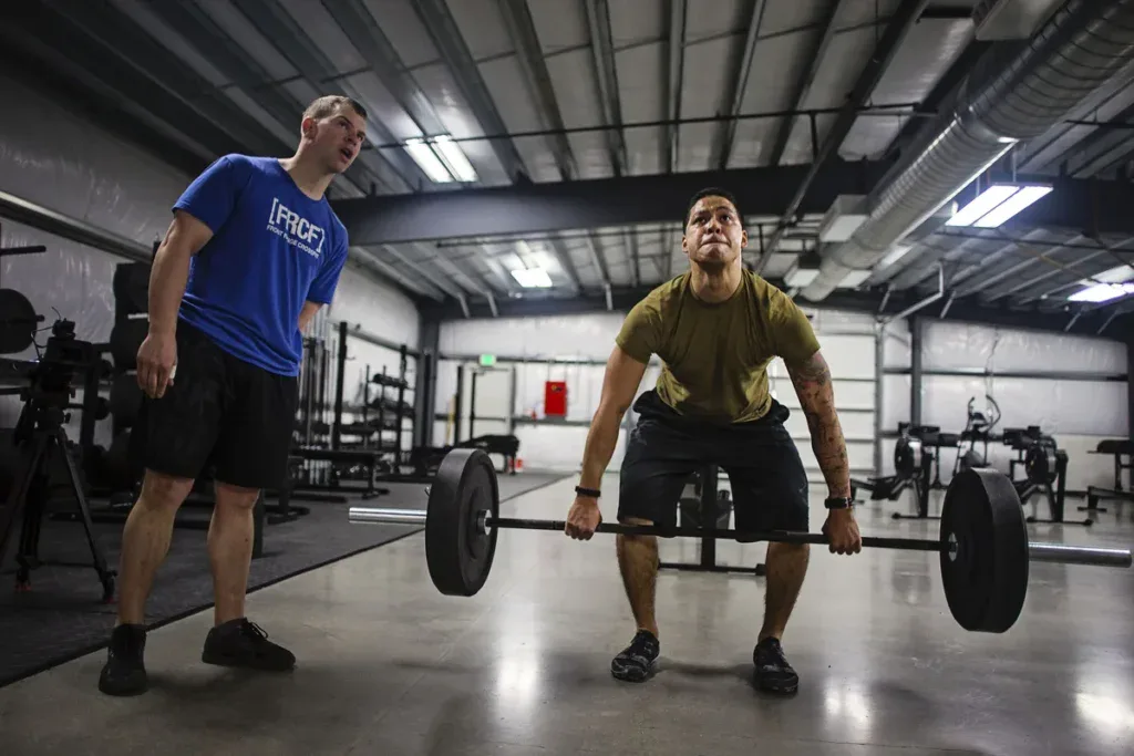 Sędzia liczy powtórzenia martwego ciągu zawodnika podczas workoutu CrossFit Open