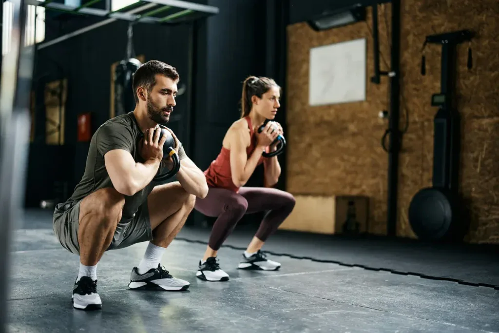Para robi przysiady z kettlebellami; na zawodach CrossFit startuje się też w parach i drużynach