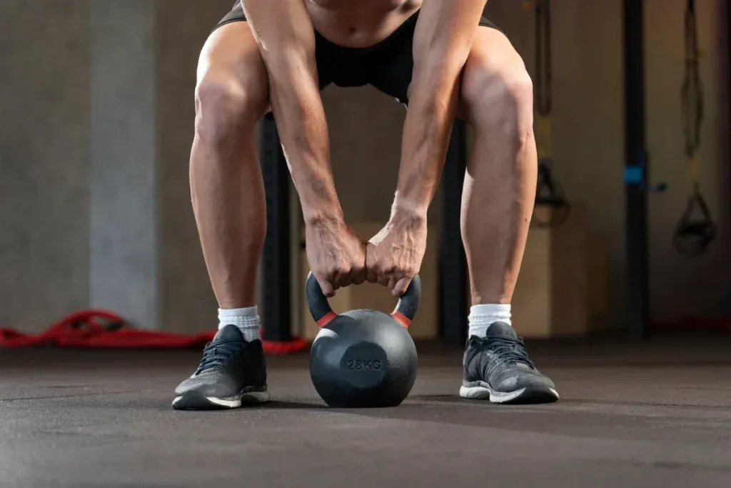 Stopy w butach treningowych przy kettlebellu, w tle lina: test buta robisz w warunkach boxu